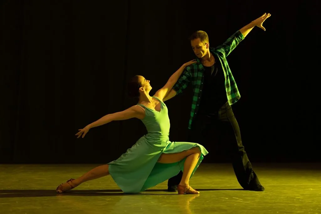 pair of dancers, a man and a woman, perform in a theater on stage in a dance musical show
