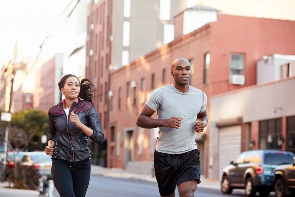 young black couple jogging in street