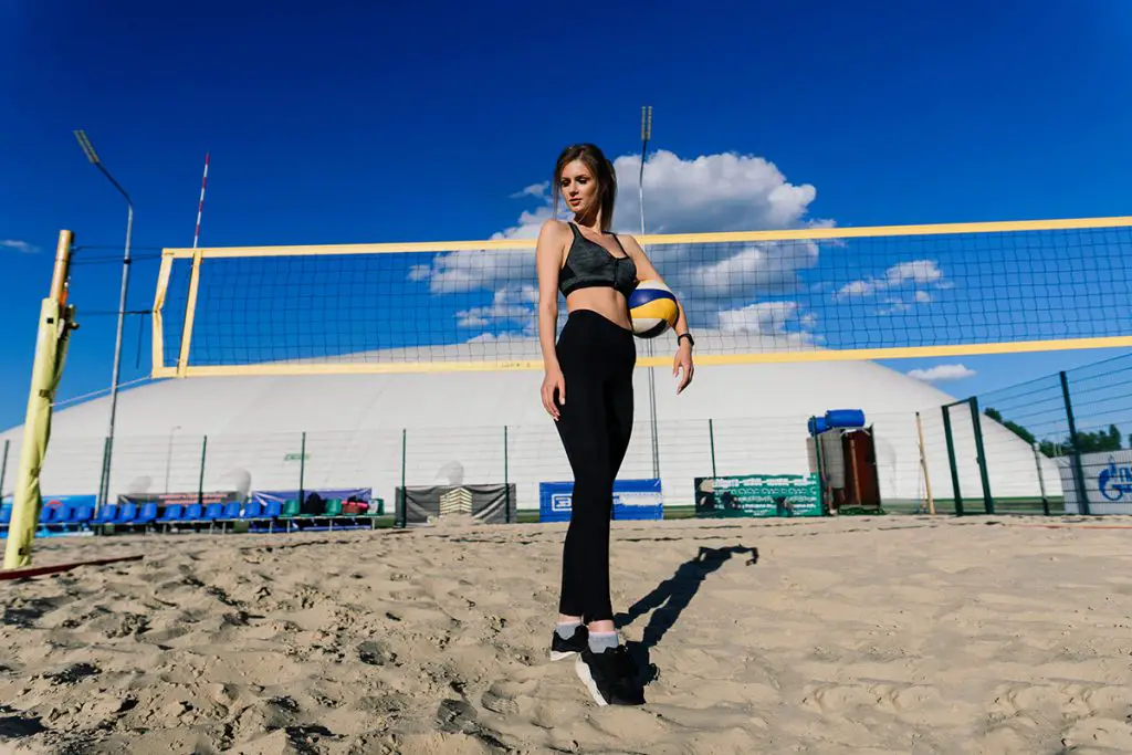 female beach volleyball player in leggings on the volleyball court