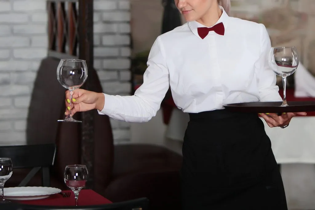 girl waitress serves glasses for win