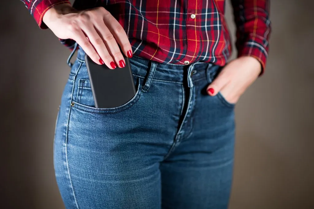 girl takes out a phone in a black case from her pocket
