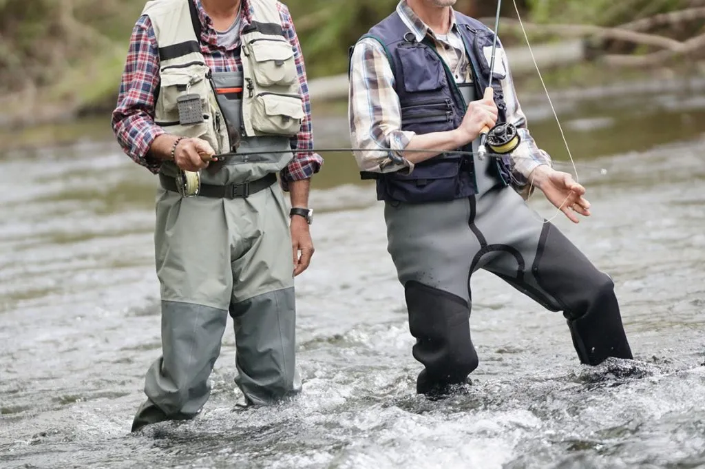 two men put on waders for fishing