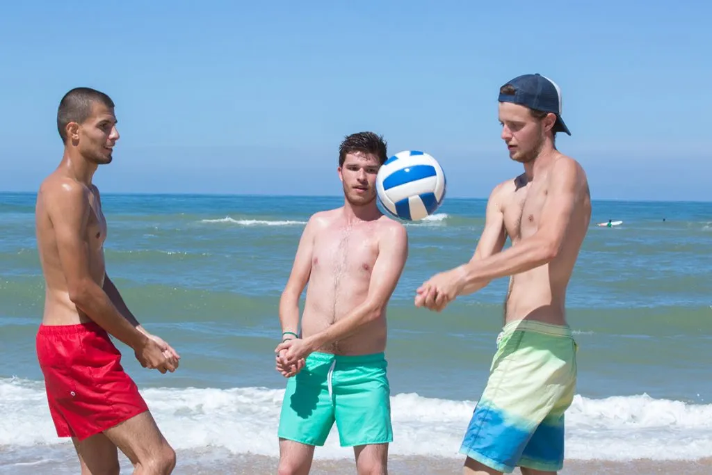 group of friends playing beach volley on the beach