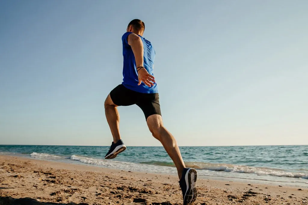 back running man runner on sandy beach sea