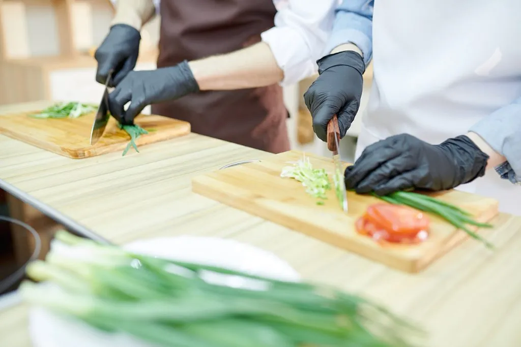  two unrecognizable female cooking in a commercial kitchen