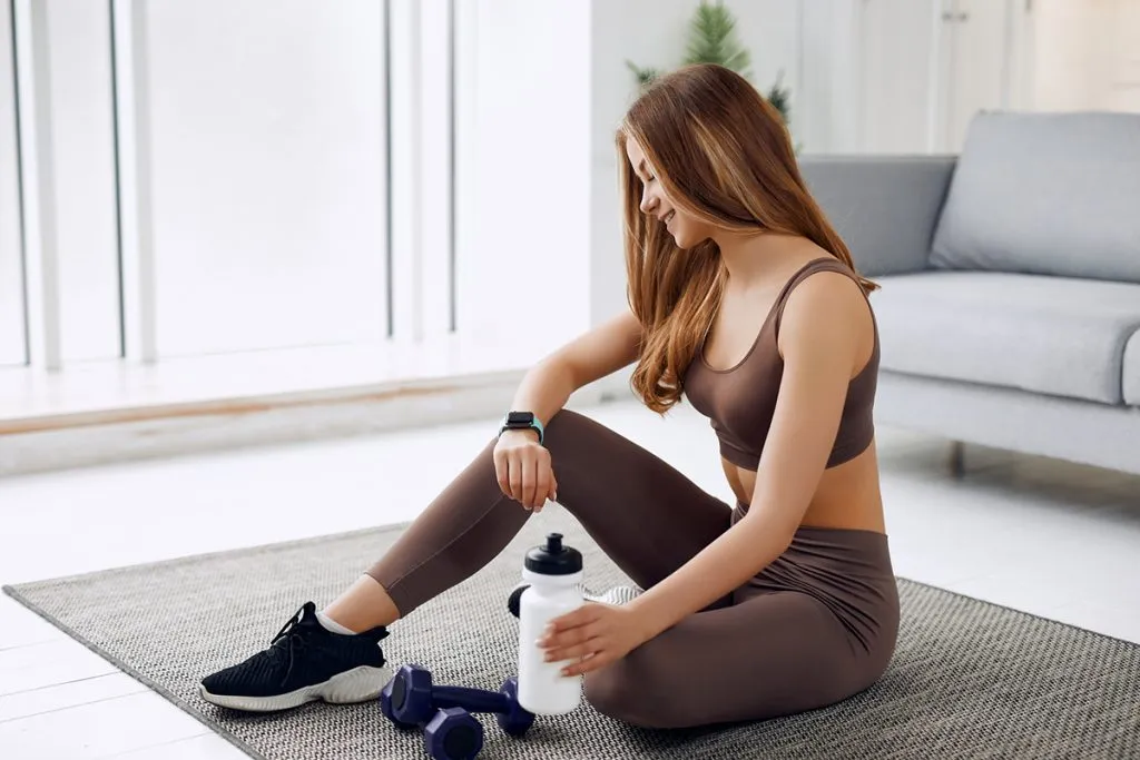 athletic girl in leggings and a top does stretching exercises