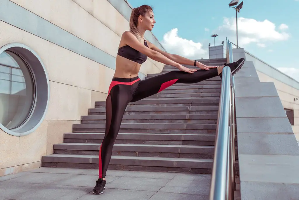girl wears leggings while stretching and gymnastics before jogging in the city
