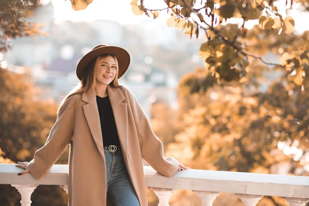 teen girl wearing hat and winter coat over nature background in park