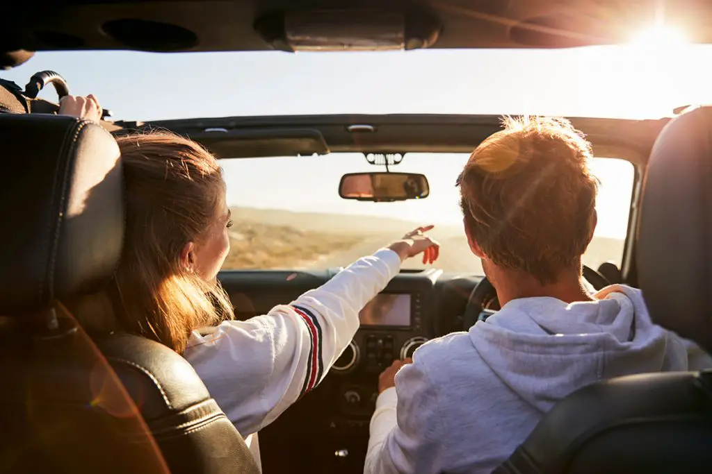 young adult couple were driving, the woman pointing out directions