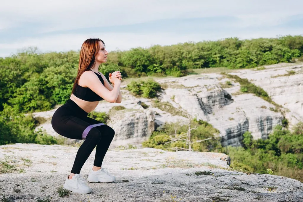 a girl wears leggings and shoes in the mountains