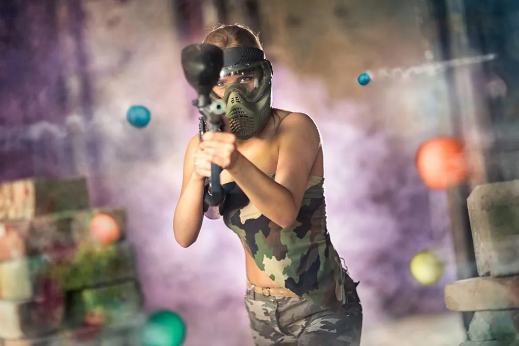 woman paintball player with marker gun