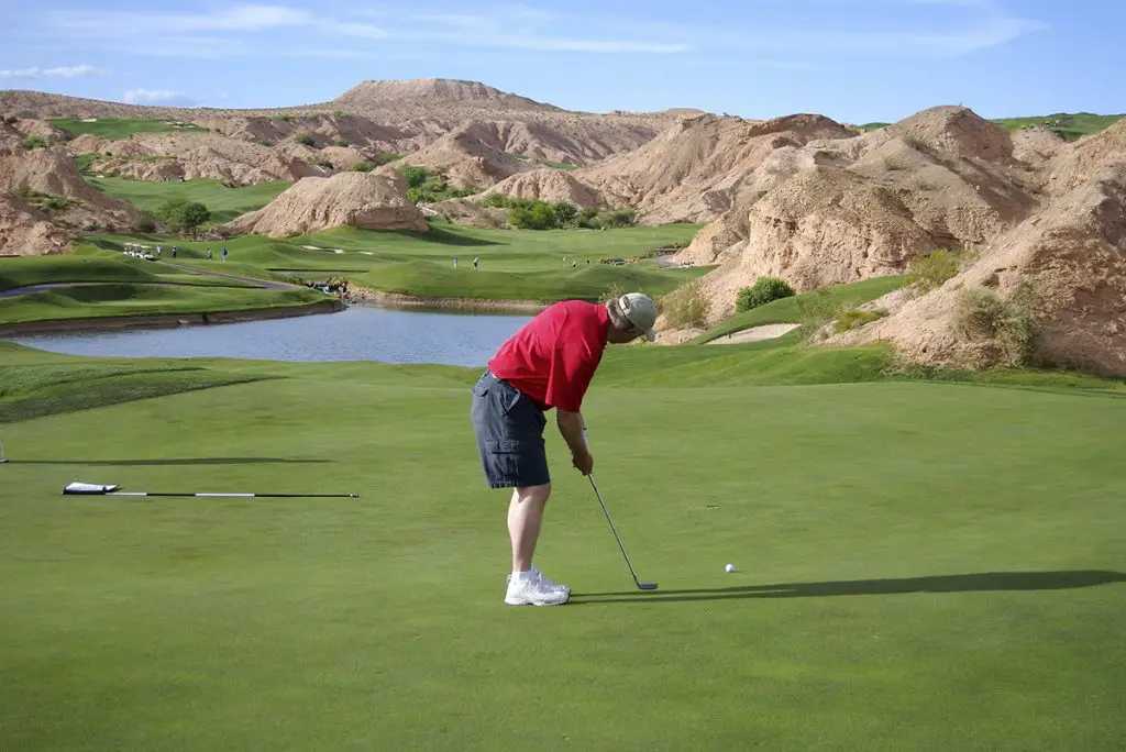 man in cargo shorts playing golf