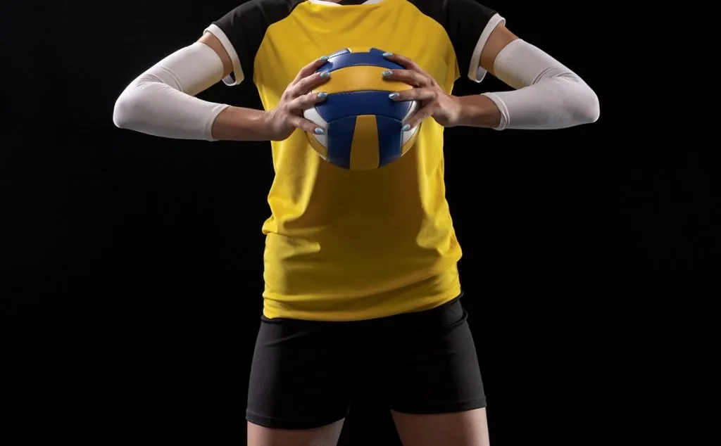 female volleyball player with black short holding ball
