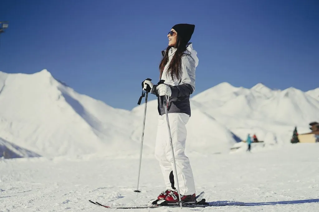 young and active brunette skiing in the snowy mountains