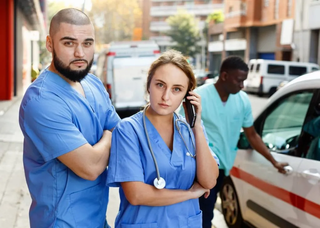 paramedics with first aid kit going to call from ambulance car