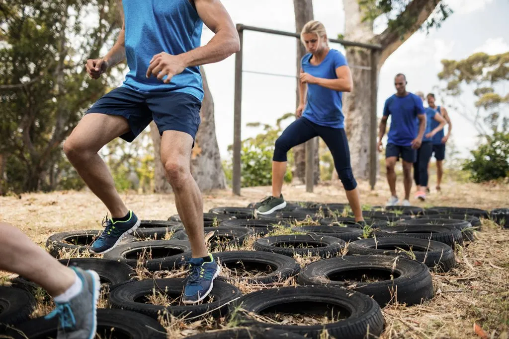 people receiving tire obstacle course training in boot camp