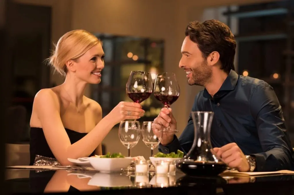 couple toasting wine glasses during a romantic dinner in a restaurant
