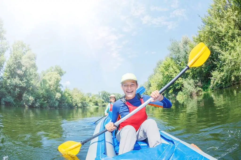 girl with her mother kayaks on the river