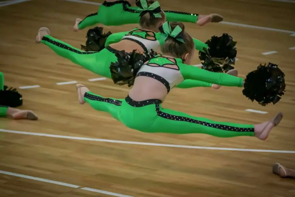 girls doing jump splits at a charleading competition