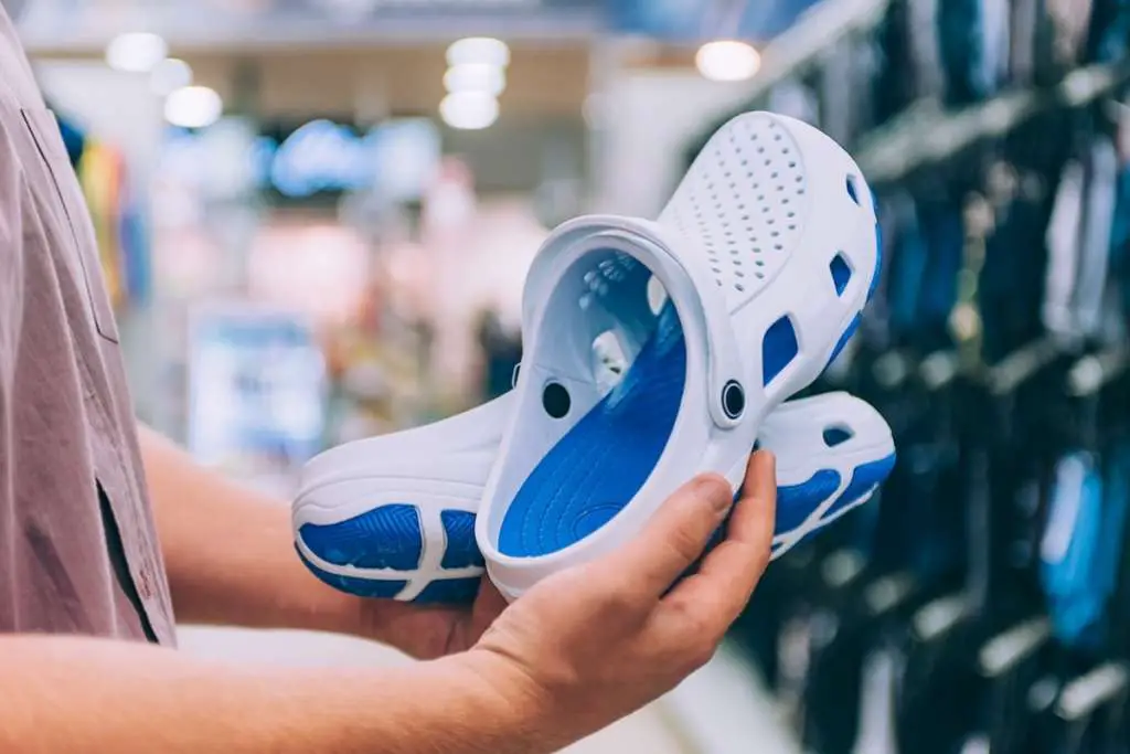 guy is holding flip-flops in the supermarket