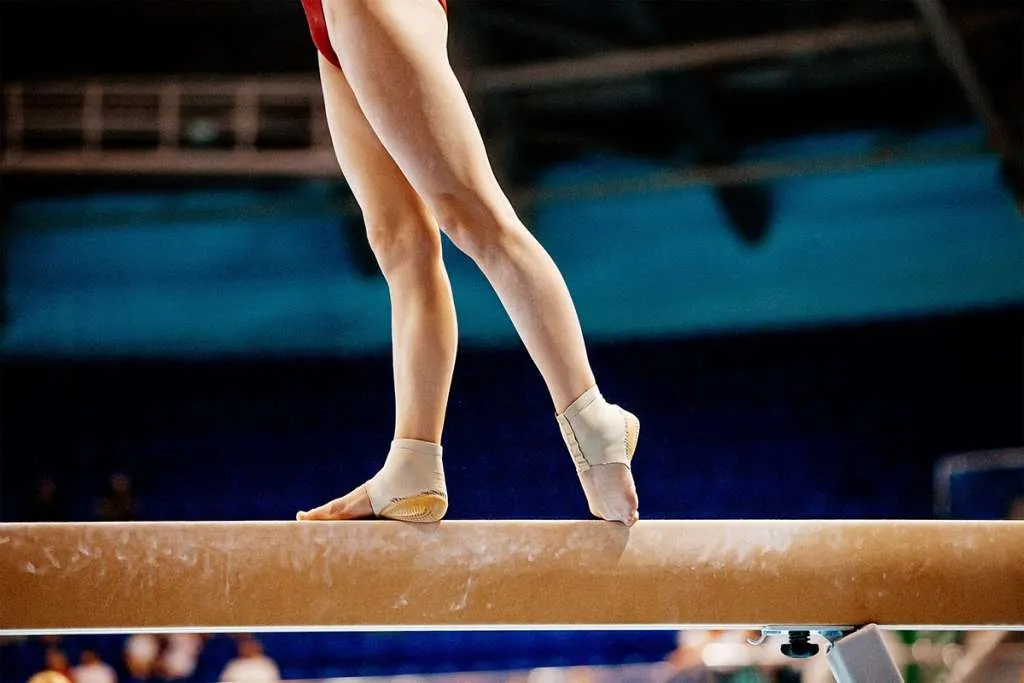 gymnast standing on wooden plank