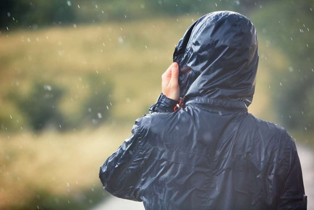 man walking in nature during heavy rain