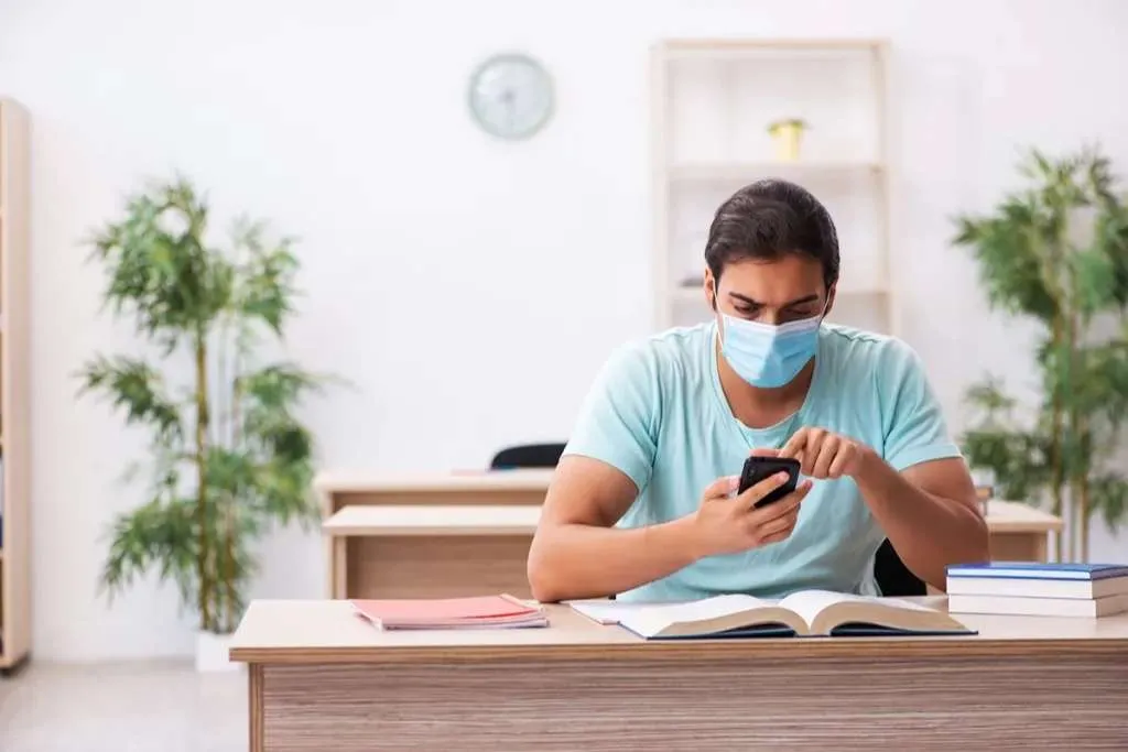 man wearing a mask sits