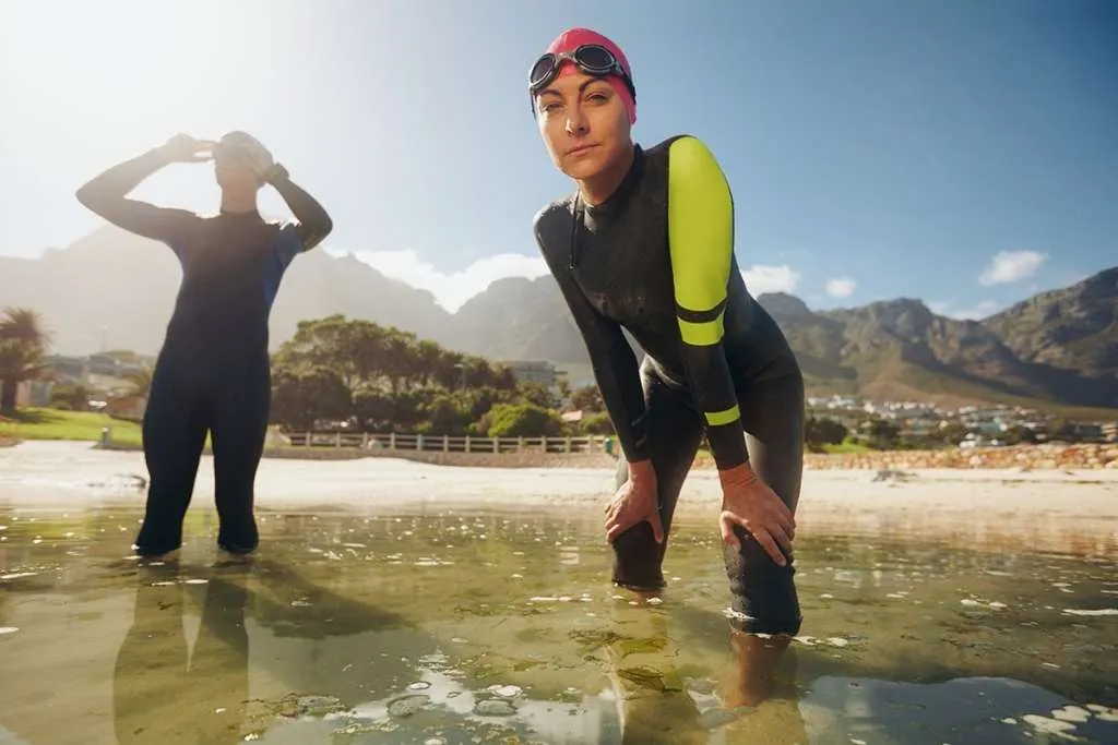 woman in wet suit standing in water 